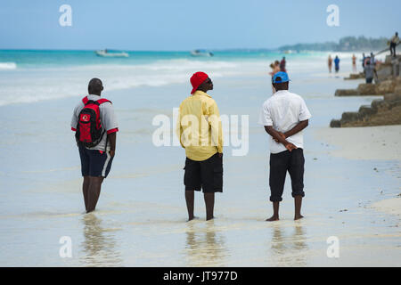 Lokale Verkäufer warten am Strand durch nahe gelegene Resort für Touristen, Diani, Kenia Stockfoto