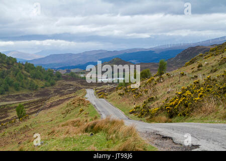 Bergige Landschaft im schottischen Hochland durch schmale Straße getrennt führenden zum Loch Tarff und die Berge am Horizont unter Geschichte sky, Schottland Stockfoto