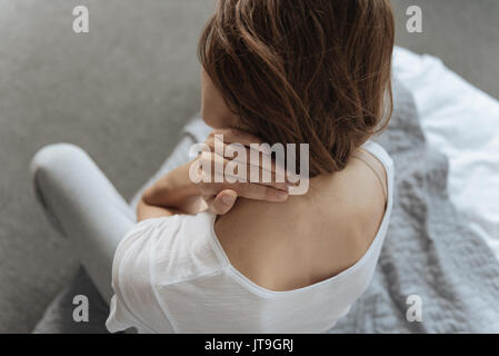 Unglückliche junge Frau leiden unter Schmerzen im Nacken Stockfoto