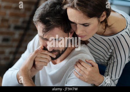 Angenehme sorgende Frau ihrem Freund umarmen Stockfoto