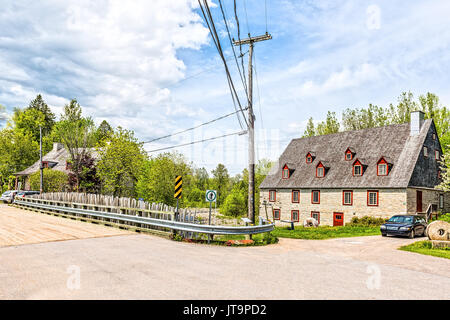 Deschambault, Kanada - 29. Mai 2017: Stone Cottage buntes Haus "Moulin de la Chevrotiere auf der Straße Brücke und den Fluss auf Chemin du Roy highway i Stockfoto