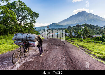 Mann, der eine Menge Gepäck auf dem Fahrrad, Virunga National Park in der Demokratischen Republik Kongo, Afrika Stockfoto