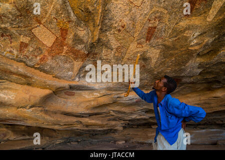 Guide zeigt auf Höhlenmalereien in Lass Geel Höhlen, Somaliland, Somalia, Afrika Stockfoto