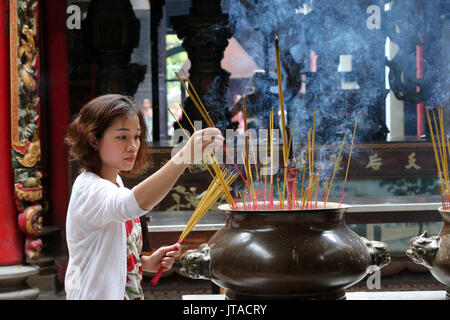 Buddhistische worshipper Inverkehrbringen Räucherstäbchen auf Joss stick Topf, taoistischen Tempel, Phuoc ein Hoi Quan Pagode, Ho Chi Minh City, Vietnam Stockfoto