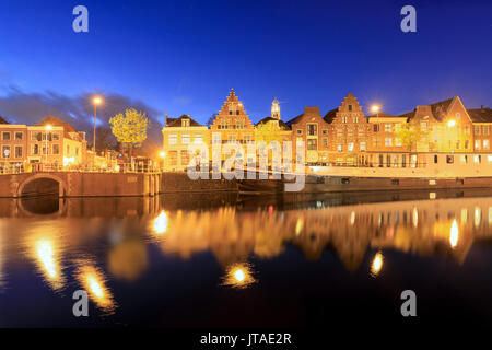 Dämmerung leuchtet auf typische Häuser und Brücke in einem Kanal des Flusses Spaarne, Haarlem, Nord Holland, Niederlande nieder Stockfoto