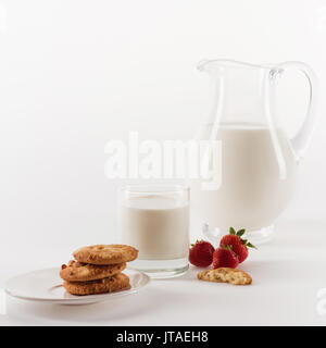 Nahaufnahme der leckere hausgemachte Cookies mit frischer Milch und Erdbeeren isoliert auf weißem Stockfoto