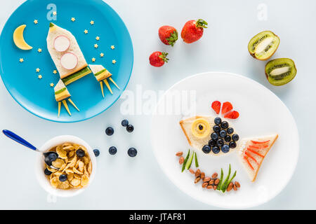 Blick von oben auf die Köstliche lustig Sandwiches auf Platten und Getreideflocken mit Früchten Stockfoto