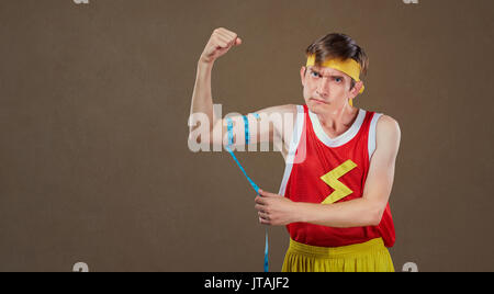 Eine lustige schlanke Mann in Sportswear Maßnahmen ein Mann in einem Zentimeter. Stockfoto