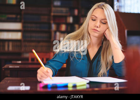 Junge Frau Lernen in der Bibliothek Stockfoto