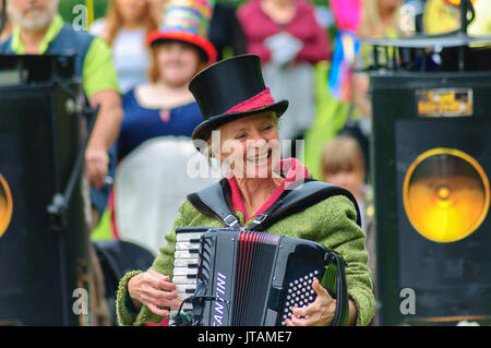 Lächelnd weibliche Musiker trägt einen Hut und Akkordeon feiern Sma Schuß Tag auf den Straßen von Paisley, Schottland am 1. Juli 2017 Stockfoto