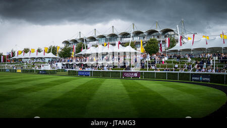 Gewitterwolken über, die Menschen um das Fahrerlager während Glorious Goodwood 2017 in West Sussex sammeln Stockfoto