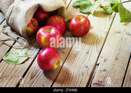 Rote Äpfel in einem Beutel auf alten hölzernen Hintergrund Reif Stockfoto