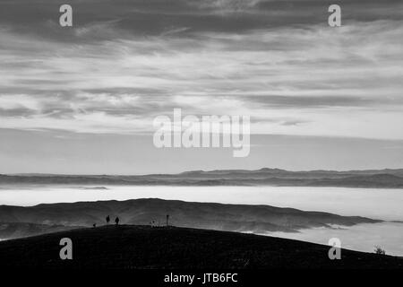 Ein Paar auf einem Berg in einem Meer von Nebel, füllen das Tal Stockfoto