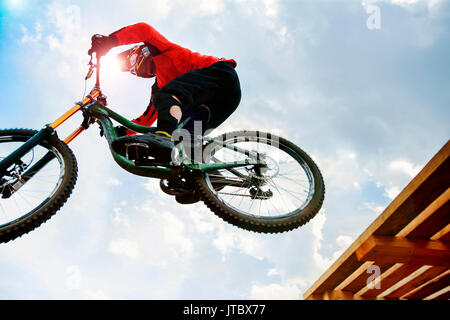 Mann Reiter fällt auf Springen Mountainbiking im Sonnenlicht Stockfoto