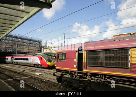 Virgin Trains Class 390 Pendolino Hochgeschwindigkeitszug und EWS Class 66 Diesel Lokomotive in Carlisle Station. UK. Stockfoto