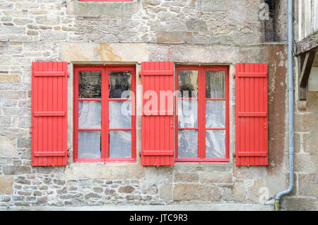 Roten Fenstern und roten Fensterläden auf einem alten Haus aus Stein die ummauerte Stadt Dinan in der Bretagne, Frankreich Stockfoto