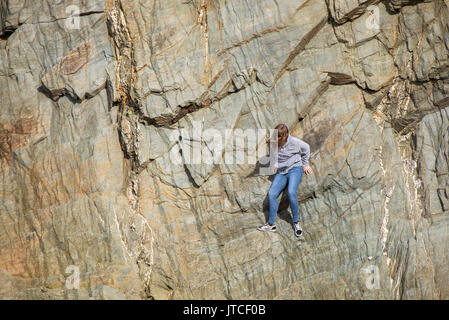 Ein junges Mädchen auf einer Felswand stecken. Stockfoto