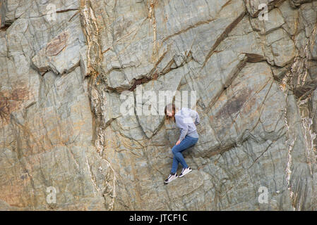 Ein junges Mädchen auf einer Felswand stecken. Stockfoto