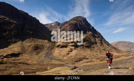 Eine schottische Piper in Glencoe, Schottland, UK Stockfoto