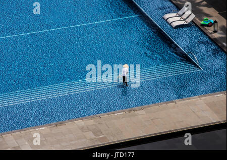 Mann Reinigung Outdoor Swimmingpool in einem tropischen Hotel Stockfoto