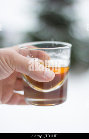 Hand mit einem Glas Whiskey Stockfoto