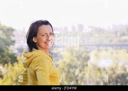 Portrait von reife Frau getragen im Sport Kleidung in den Park. Attraktive, reife Frau halten fit und gesund suchen Stockfoto