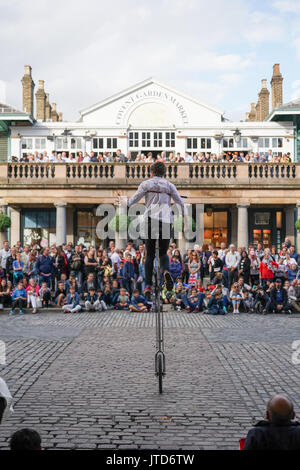 Ein entfesselungskünstler Einradfahrer durchführen für Massen in Covent Garden in London. Aus einer Reihe von Bildern von Straßenkünstlern in London, UK. Foto Datum: Stockfoto