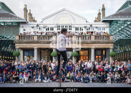 Ein entfesselungskünstler Einradfahrer durchführen für Massen in Covent Garden in London. Aus einer Reihe von Bildern von Straßenkünstlern in London, UK. Foto Datum: Stockfoto