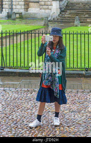 Tourist macht ein Selfie vor Radcliffe Camera in Oxford, Oxfordshire UK im August an einem regnerischen Tag Stockfoto