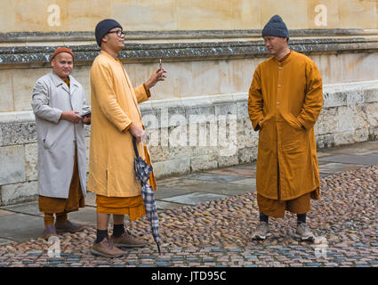 Buddhistische Mönche in ihren Gewändern, Mänteln und Hüten besuchen Oxford, Oxfordshire UK im August an einem nassen Tag Stockfoto