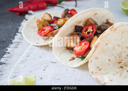 Drei Tacos mit gegrillten Champignons, Spanisch würzige Wurst Chorizo, mexikanische Tortillas, die zyprische Käse Halloumi, hot Chilly, getrockneten Oregano, Scheibe lim Stockfoto