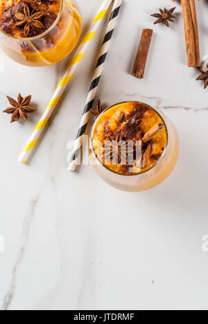 Traditionelle herbst Gerichte, pikant Pumpkin Pie Smoothie mit Zimt, Anis und Haferflocken. Portioniert in Gläser, auf weissem Marmortisch. Kopieren Raum oben vi. Stockfoto