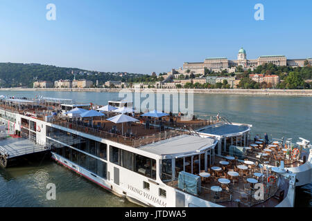 Viking River Cruises Kreuzfahrtschiffe mit dem Königlichen Palast am Schlossberg hinter, Budapest, Ungarn Stockfoto
