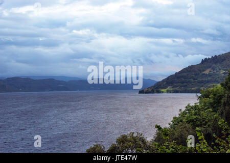 Schottland, Highlands, Schottische Landschaft, Klares Wasser, Meer, Berggipfel, Blaues Wasser, Bäume, Landschaft, Natur, Loch Ness, Dramatische Skyline Stockfoto