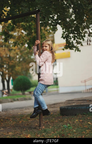 Foto der Jungen glücklich Mädchen Schwingen auf der Querstrebe Stockfoto