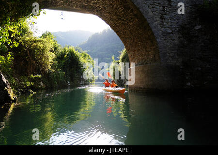 Mutter und Sohn Kajakfahren in gelb Kajak unter einer Brücke in den meisten na Soci, Slowenien. Stockfoto