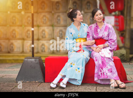 Besten Freundinnen sitzen auf der Kultur Street in japanischen Festival mit ordentlichen Laterne Hintergrund, Frauen in Japan traditionellen Kimono genießen Kunst Stockfoto