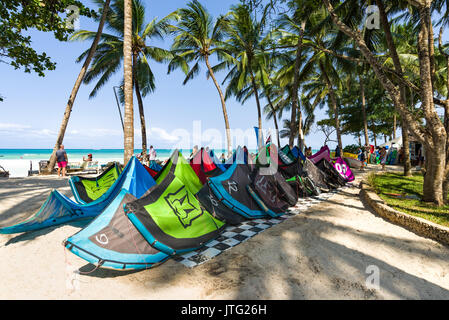 Drachen aufgereiht auf Beach Front Resort mit Touristen, Palmen, Strand und Meer im Hintergrund Stockfoto