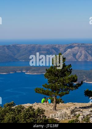 Vidova Gora auf der Insel Brac in Kroatien junges Paar von hinten auf dem Berg ruhen Beobachten panorama Seascape Stockfoto