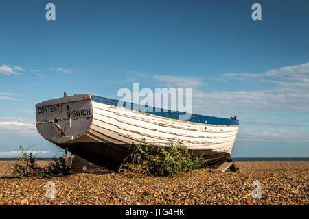 Historische hölzerne Fischerboote sitzen im Sommer Sonne auf der Kiesstrand in Aldeburgh an der Küste von Suffolk in Großbritannien. Stockfoto