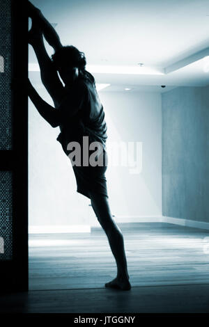 Männliche Yogalehrer tun teilt Bein Strecken Flexibilität Gymnastik und Yoga Asanapraxis im Fitness-Studio Stockfoto