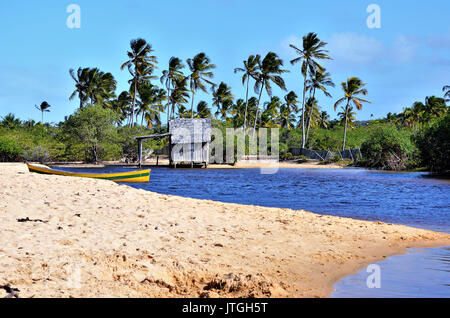 Kleines Holzhaus auf einem brasilianischen Küste Strand durch den kleinen Fluss Bank in Canoa Quebrada in der Stadt Porto Seguro, Bahia, Brasilien umgeben. Stockfoto