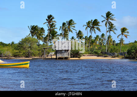 Kleines Holzhaus auf einem brasilianischen Küste Strand durch den kleinen Fluss Bank in Canoa Quebrada in der Stadt Porto Seguro, Bahia, Brasilien umgeben. Stockfoto