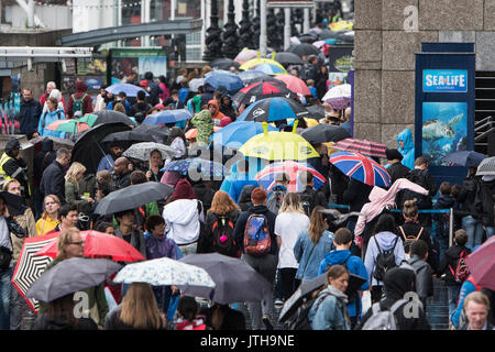 London, Großbritannien. 9. August 2017. Touristen nutzen Sie Sonnenschirme an der Königin in London, UK als schwerer Regen die Stadt trifft. Credit: Ben Furst/Alamy Leben Nachrichten. Stockfoto