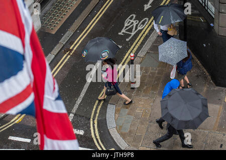 London, Großbritannien. 9. August 2017. Die in der City arbeiten, und Touristen logieren auf Cornhill, wie sie Ausweichen der Regen unter ihren Schirmen versuchen. Credit: Guy Bell/Alamy leben Nachrichten Stockfoto