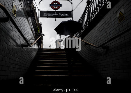 London, Großbritannien. 9. August 2017. Ein Pendler in U-Bahnhof Westminster in London, Großbritannien, als der Regen trifft die Stadt. Credit: Ben Furst/Alamy Leben Nachrichten. Stockfoto