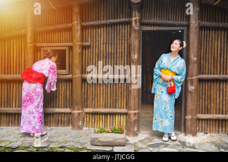 Schöne attraktive reisende Frauen in traditioneller Kleidung Kimono, Holzhaus und Anzeigen von japanischen Sehenswürdigkeiten antike Architektur d Stockfoto