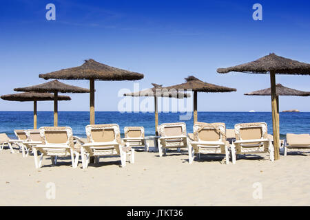 Liegen und Schirme an einem schönen Sandstrand in Ibiza Stockfoto