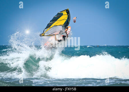 Windsurfen-Sprünge aus dem Wasser sehr hoch über der Welle Stockfoto