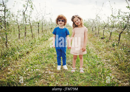 Kleinen Jungen und Mädchen im blühenden Garten Stockfoto